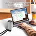 100W fast charging 20000mAh power bank connected to laptop on desk with coffee cup in background TUTT
