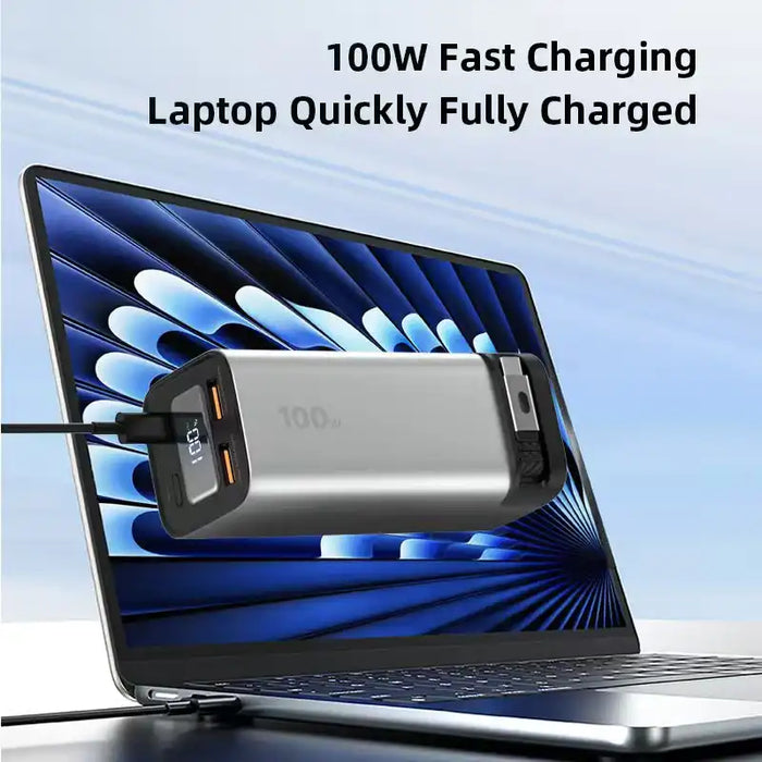 Silver 100W 20000mAh fast charging power bank connected to laptop showing digital screen charging status TUTT