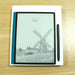 E-reader with black stylus pen on wooden table displaying windmill sketch and wake up loading bar TUTT