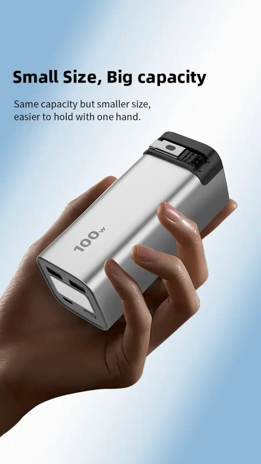 Hand holding compact 100W silver laptop power bank with foldable plug and USB ports on gradient blue background TUTT