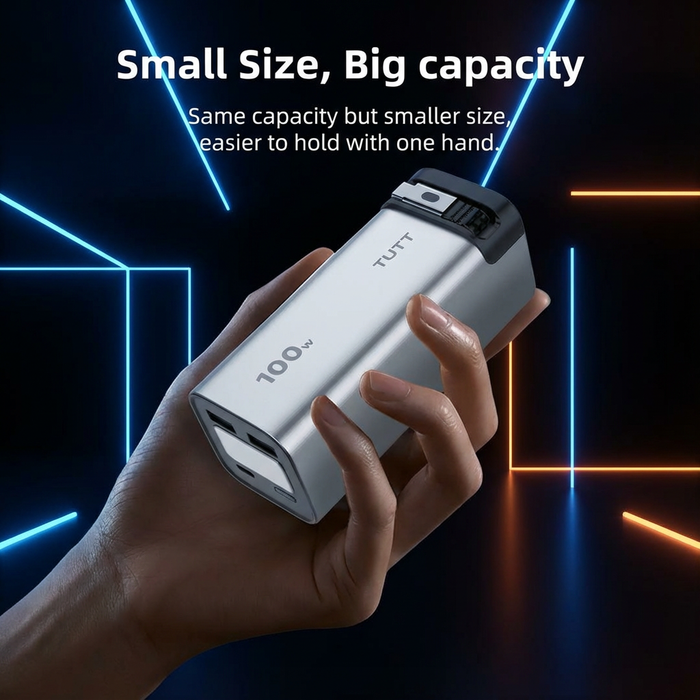 Hand holding a power bank with 'TUTT' branding against a dark background with neon lights.