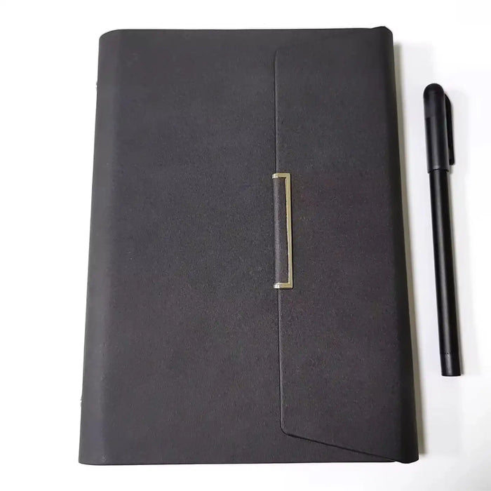 Closed black leather notebook with gold clasp and black pen on white background TUTT